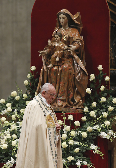 Pope Francis walks past a statue of Mary and the child Jesus during a prayer service New Year's Eve in St. Peter's Basilica at the Vatican. (CNS photo/Paul Haring) See POPE-YEAREND Dec. 31, 2014.